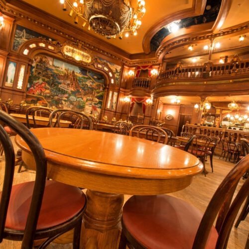 3 Houten ronde tafels met stoelen in het Lucky Nugget restaurant