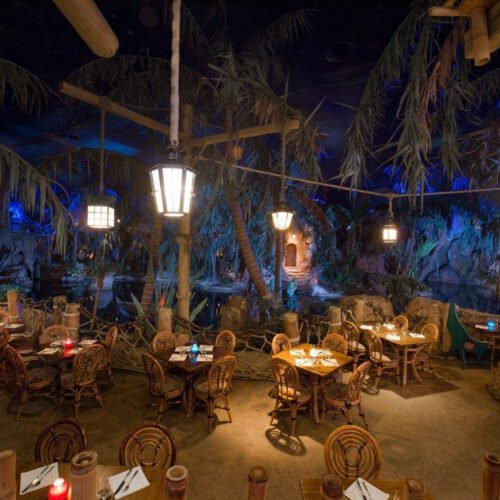 Captain Jacks Captain Jacks restaurant tussen de palmbomen met rieten stoel en tafels in Adventureland