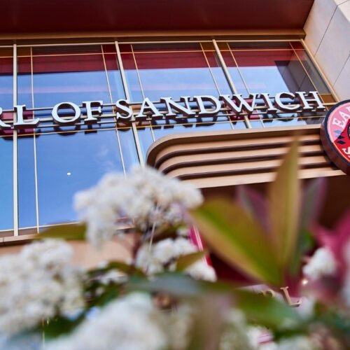 7 Ingang Earl of Sandwich met witte bloemen ervoor