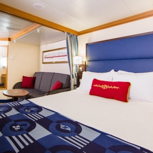 2 Tweepersoonsbed en een bank met rode kussens in een Deluxe oceanview stateroom obstructed veranda