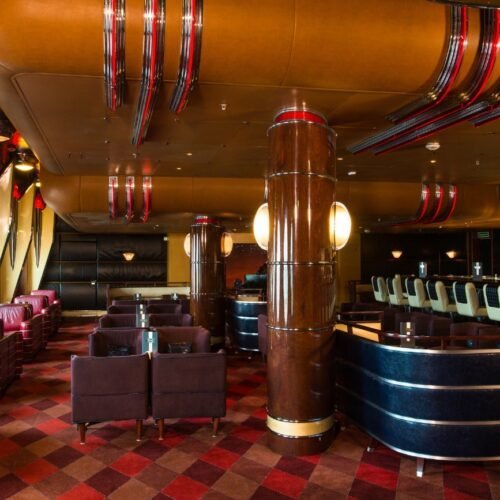 4Restaurants Bar met rode leren stoelen en rood geblokte vloerbedekking aan boord van de Disney WonderBar met rode leren stoelen en rood geblokte vloerbedekking aan boord van de Disney Wonder