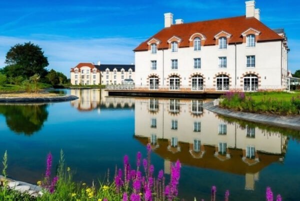 Water met paarse bloemen en wit gebouw Villa's bij Staycity