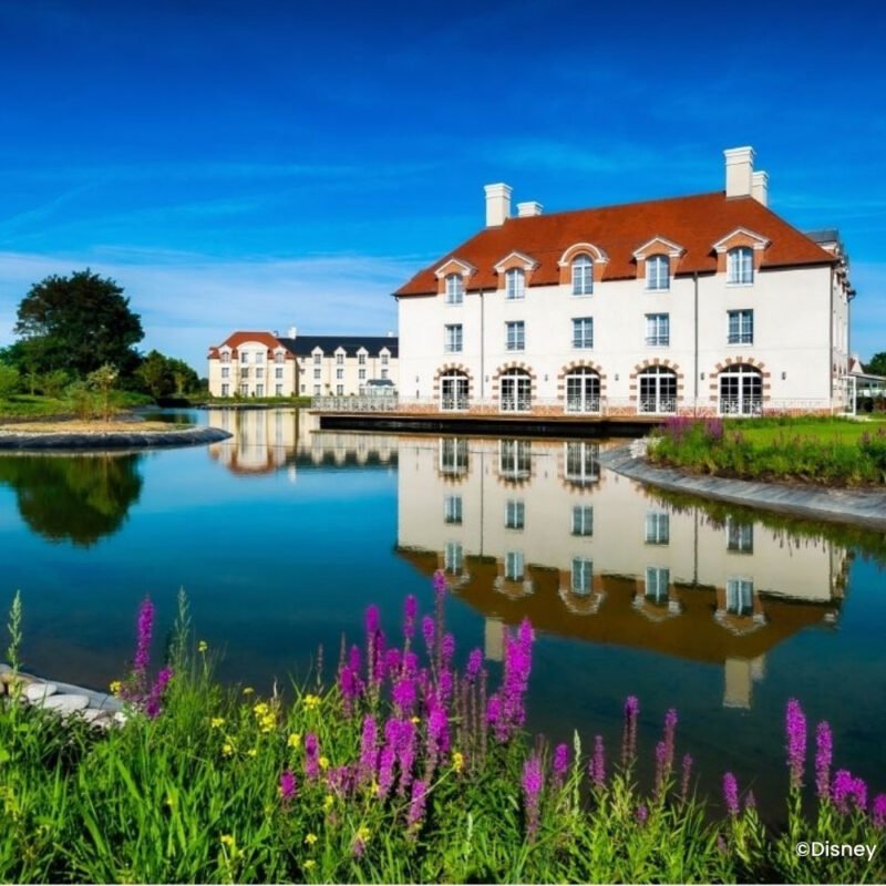Water met paarse bloemen en wit gebouw Villa's bij Staycity
