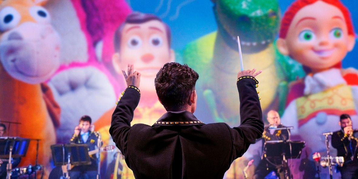 Dirigent voor een live orkest voor een scherm met Disney Pixar Figuren 
