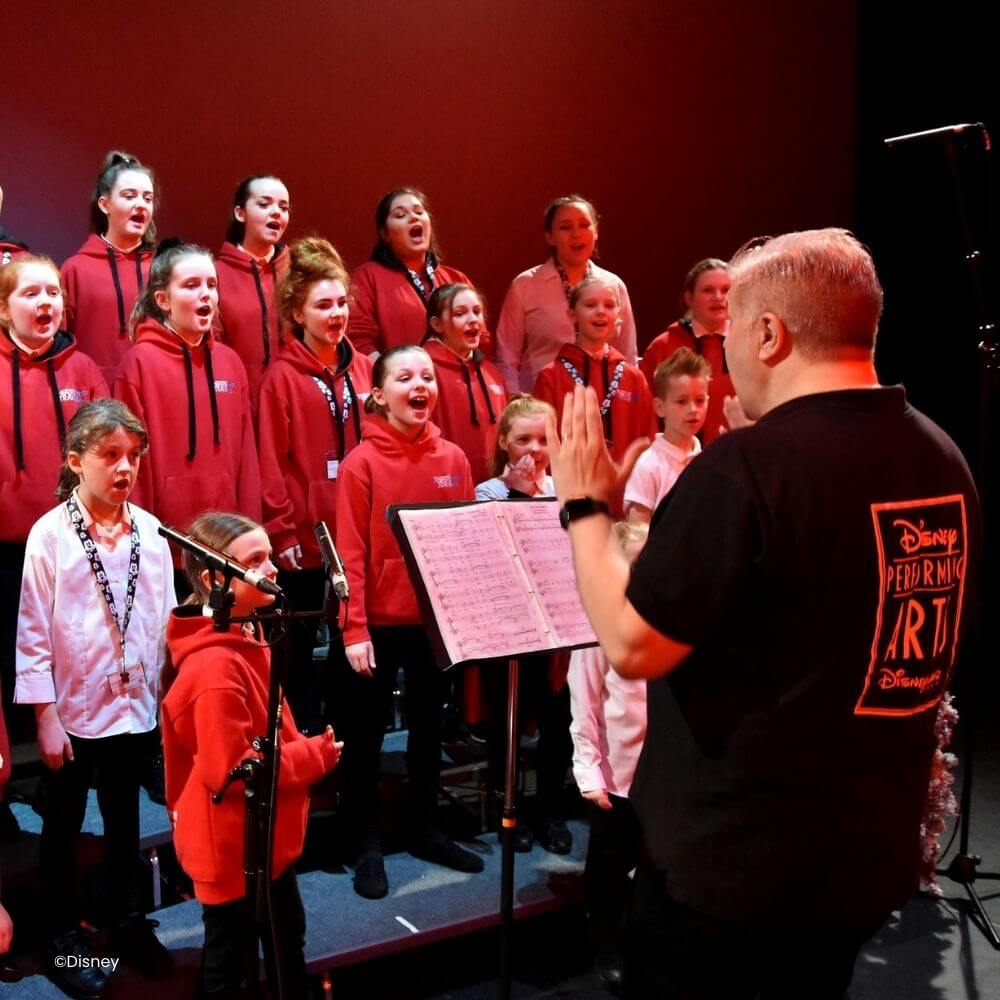 Kinderen tijdens een workshop van Disney Performing Arts met een Disney Castmember