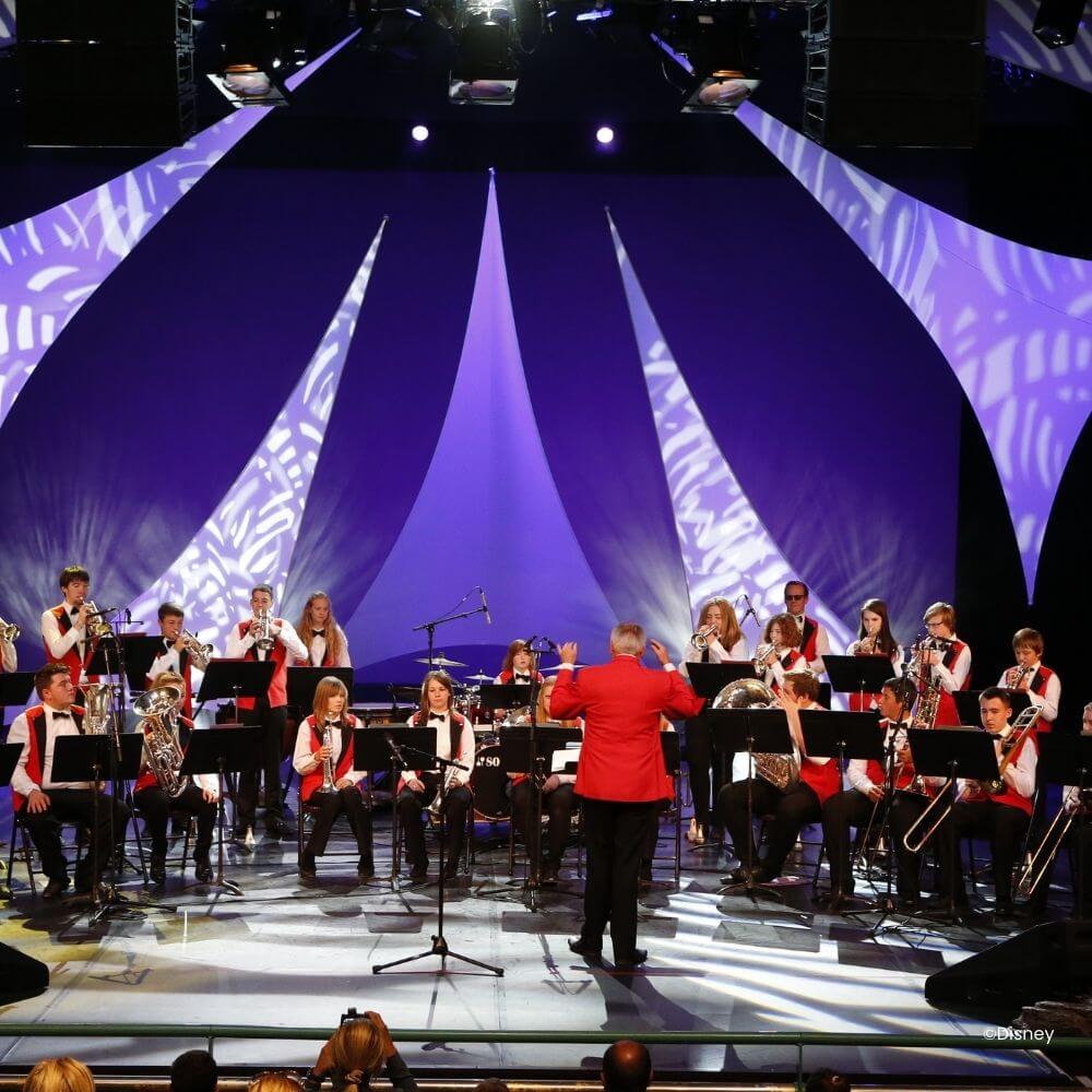 Orkest en dirigent met rood jasje op een podium kalender Disney Performing Arts