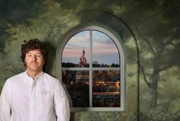 Restaurant La Forêt Secrète par Jean Imbert in het Disneyland Hotel, met een groene muur versierd met schilderingen van bomen en een raam dat uitkijkt op het magische Disneyland® Park.